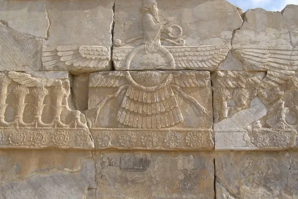 Cracked stone relief depicting the Faravahar symbol in the city of Persepolis.