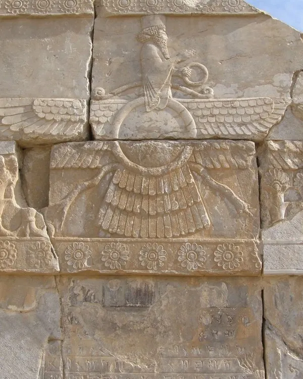 Cracked stone relief depicting the Faravahar symbol in the city of Persepolis.